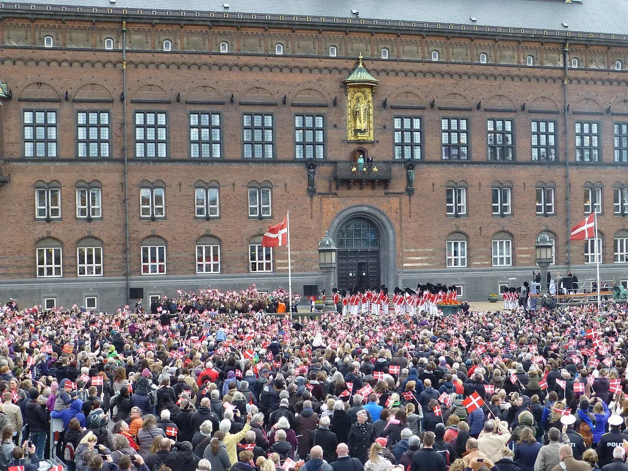 Mange mennesker fejrer dronning Margrethe II’s 75-års fødselsdag ved Københavns Rådhusplads. Stemningen er festlig med fokus på dronningen og markeringen.