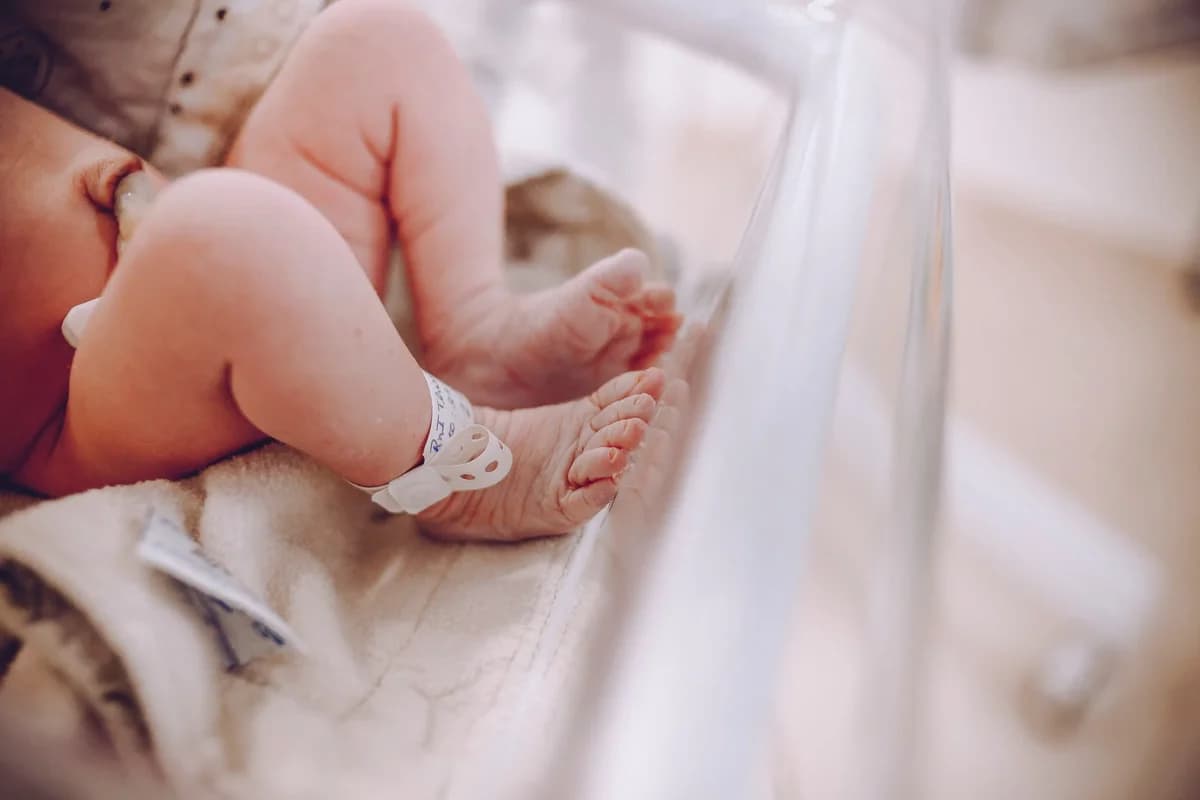 Close-up of a newborn baby's feet with a hospital wristband.