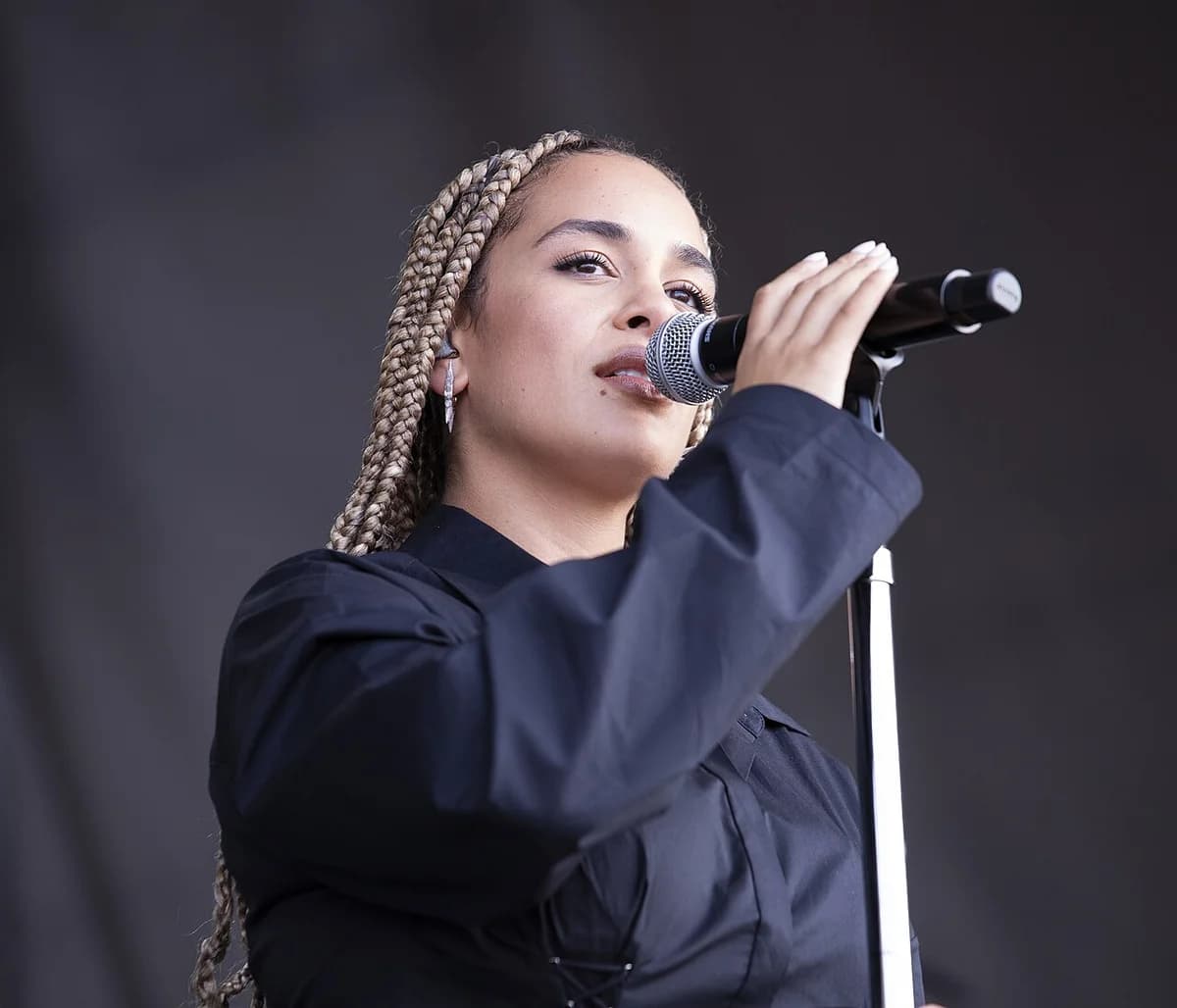 Female singer with blonde braids holding microphone
