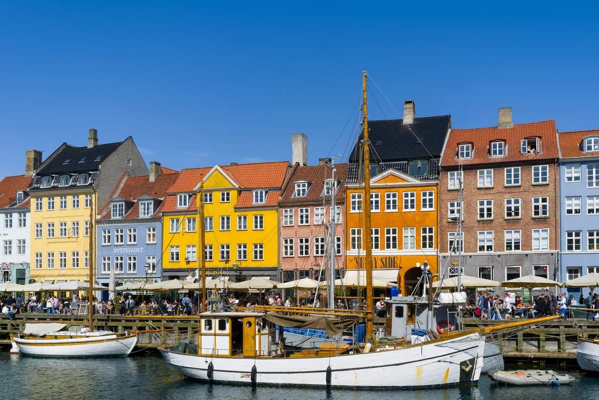 Colorful buildings and historic boats at Nyhavn harbor in Copenhagen.