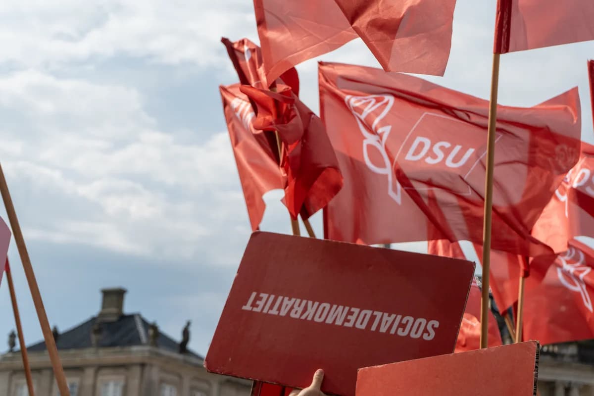 Red DSU flags and a placard at a political event in Copenhagen