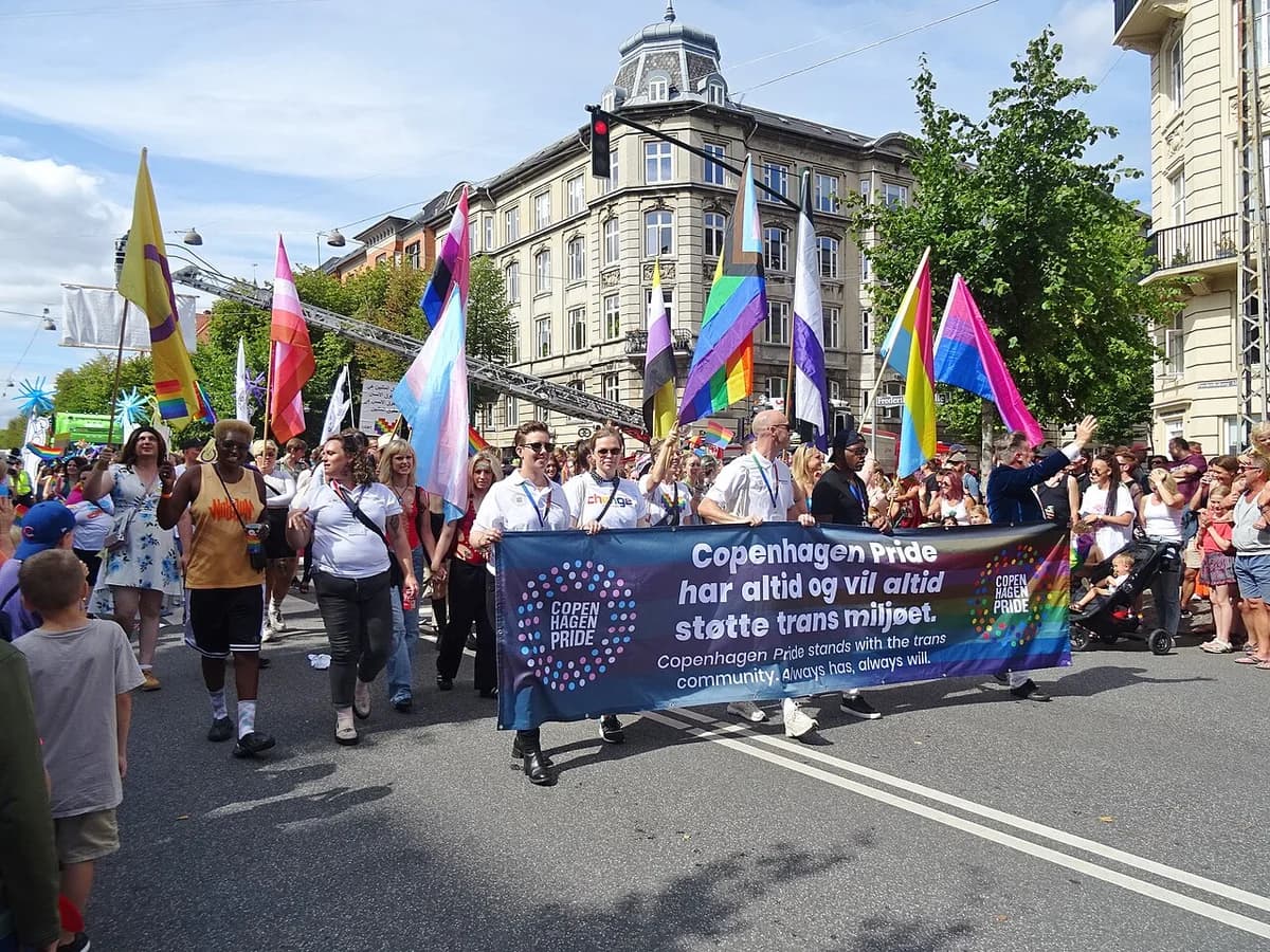 Participants in Copenhagen Pride Parade holding a banner supporting the trans community