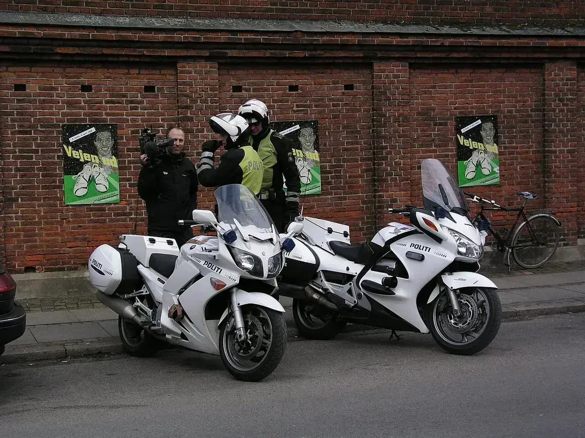 Two Danish police officers with white motorbikes on a street