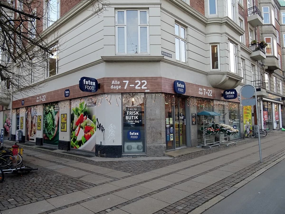 Exterior of a Føtex Food supermarket on a Copenhagen street corner with promotional signs and window displays.