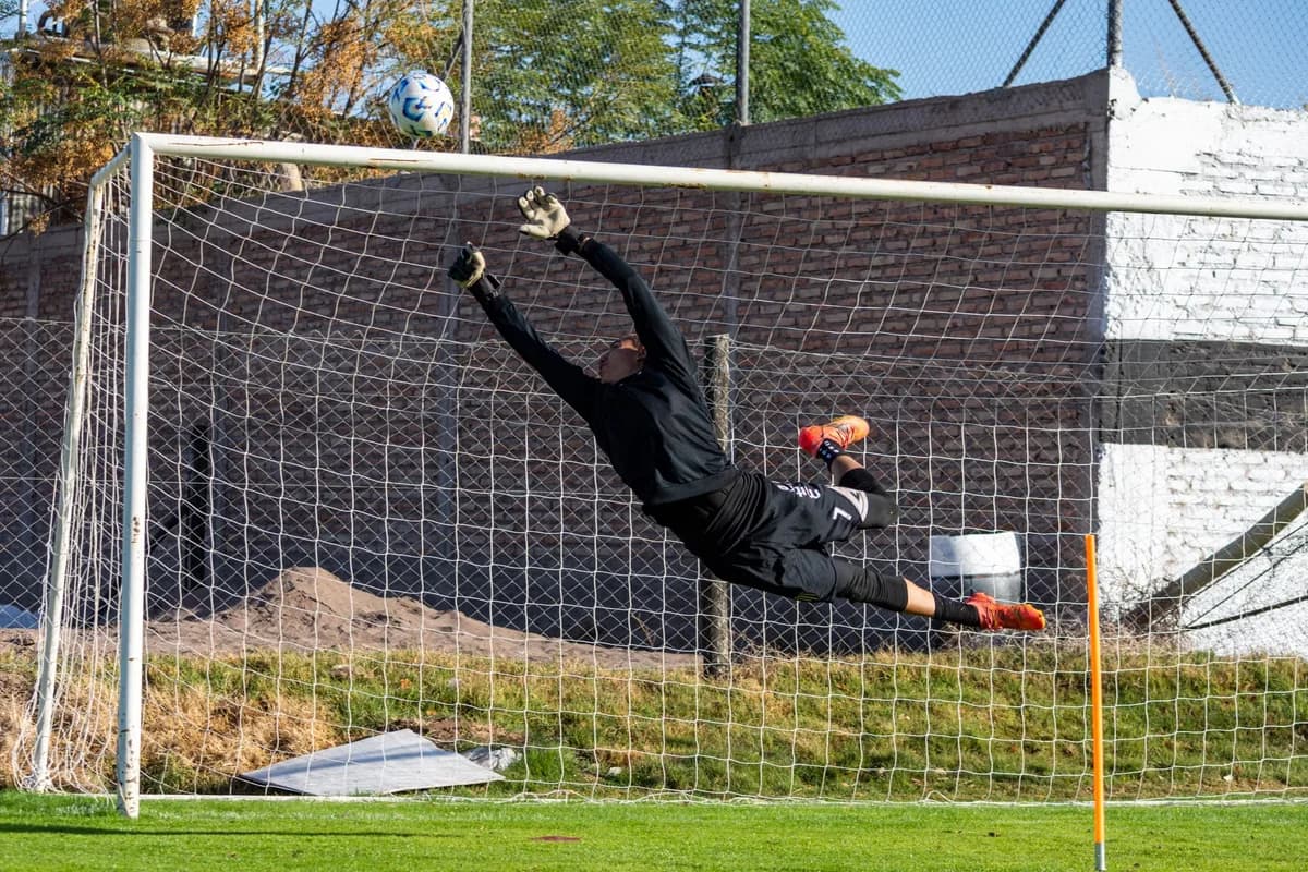 Goalkeeper diving to save soccer ball