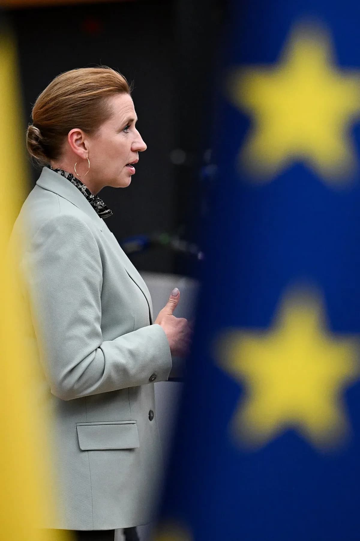 Woman speaking with blurred flags in foreground