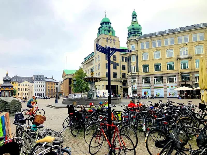 Bicycles parked in front of historic buildings and a fountain in Copenhagen city square