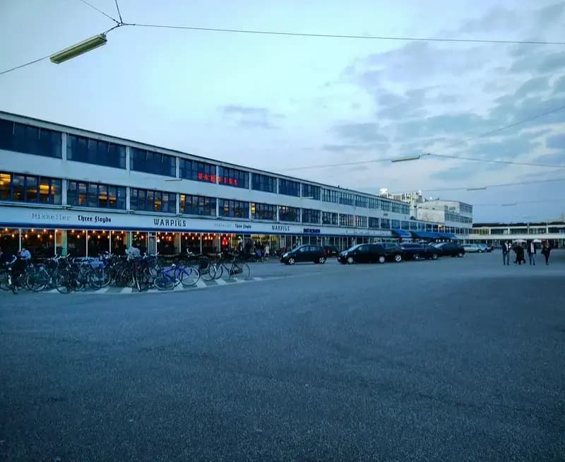 Evening scene of Kødbyen with bicycles, cars, and illuminated restaurant buildings