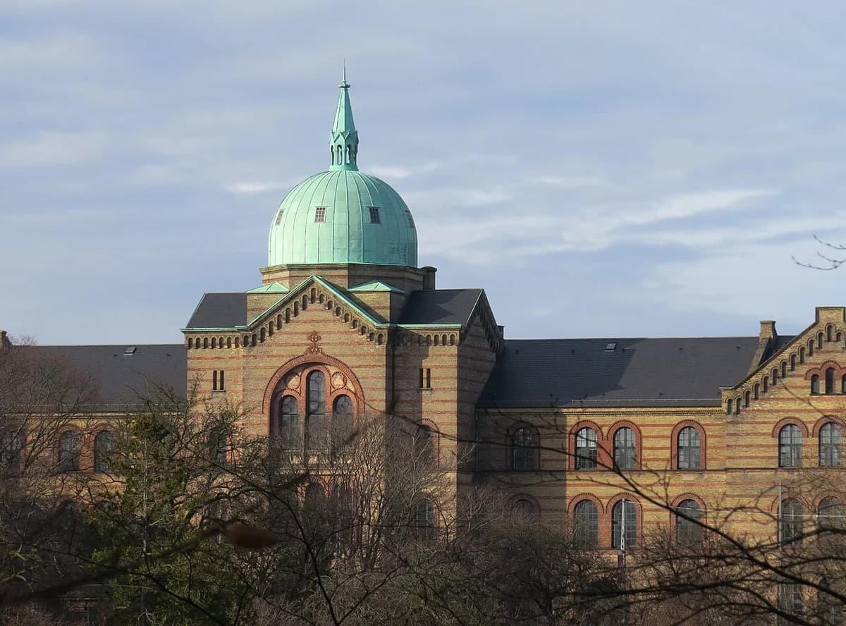 Historic building with green dome and brick facade in Copenhagen