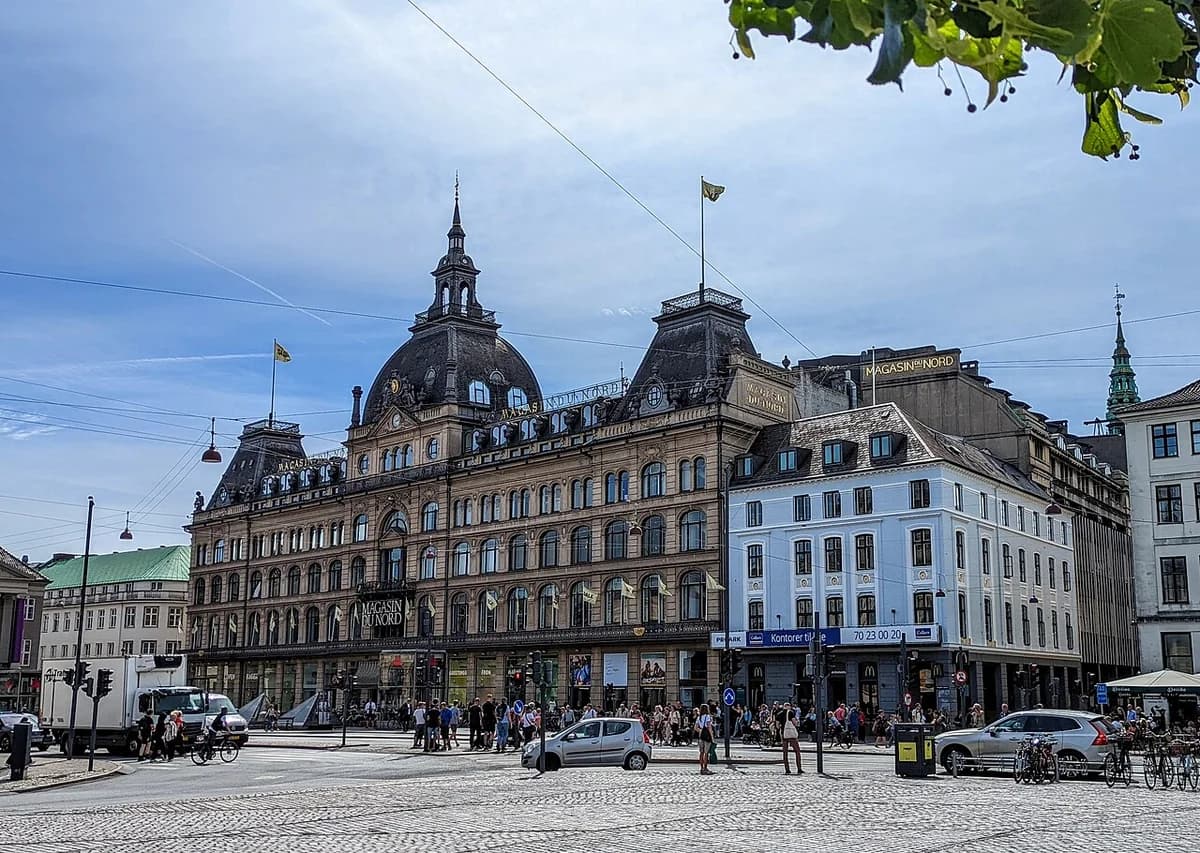 Magasin du Nord department store at Kongens Nytorv in Copenhagen with a busy square in front.