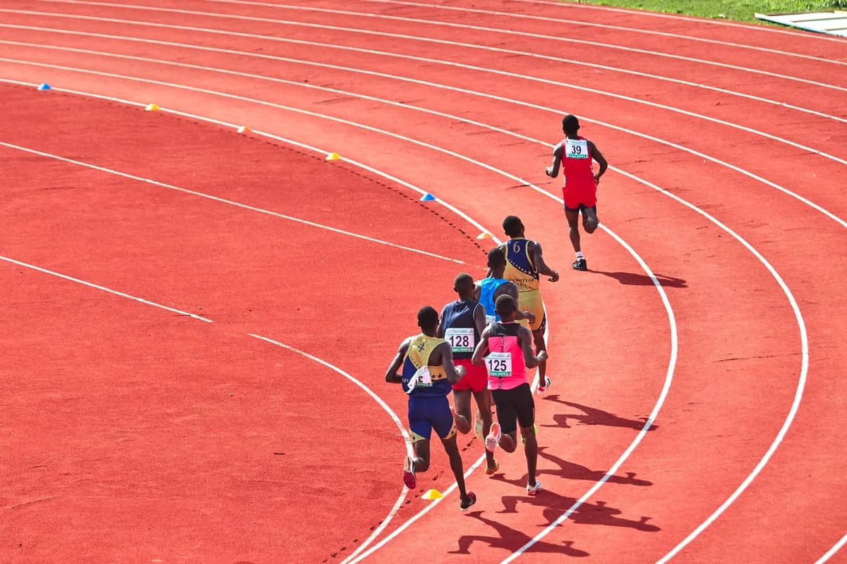 Several athletes running around a curved outdoor track in a race.