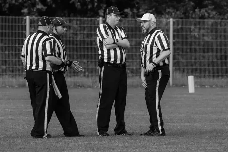 Four referees talking on a sports field
