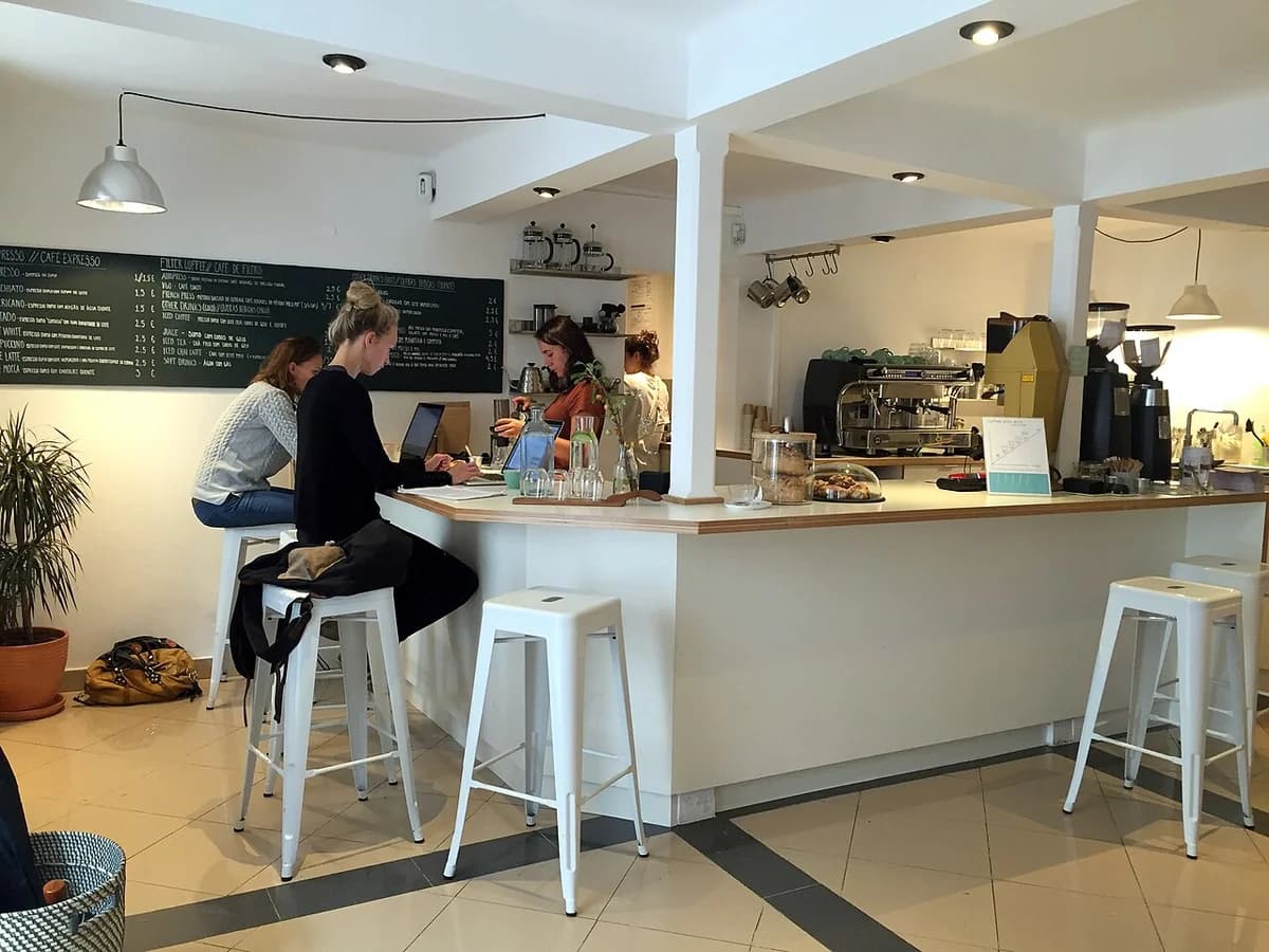Customers inside a minimalist coffee shop sitting at the counter