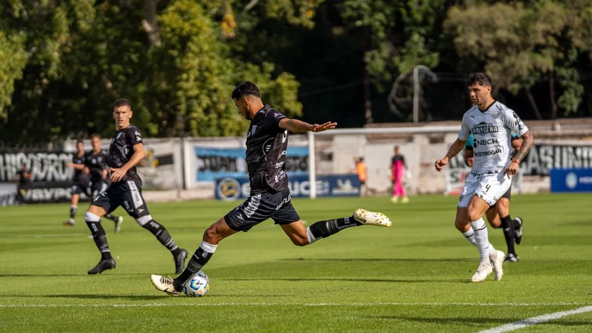 soccer player kicking ball in black uniform with opponents in white