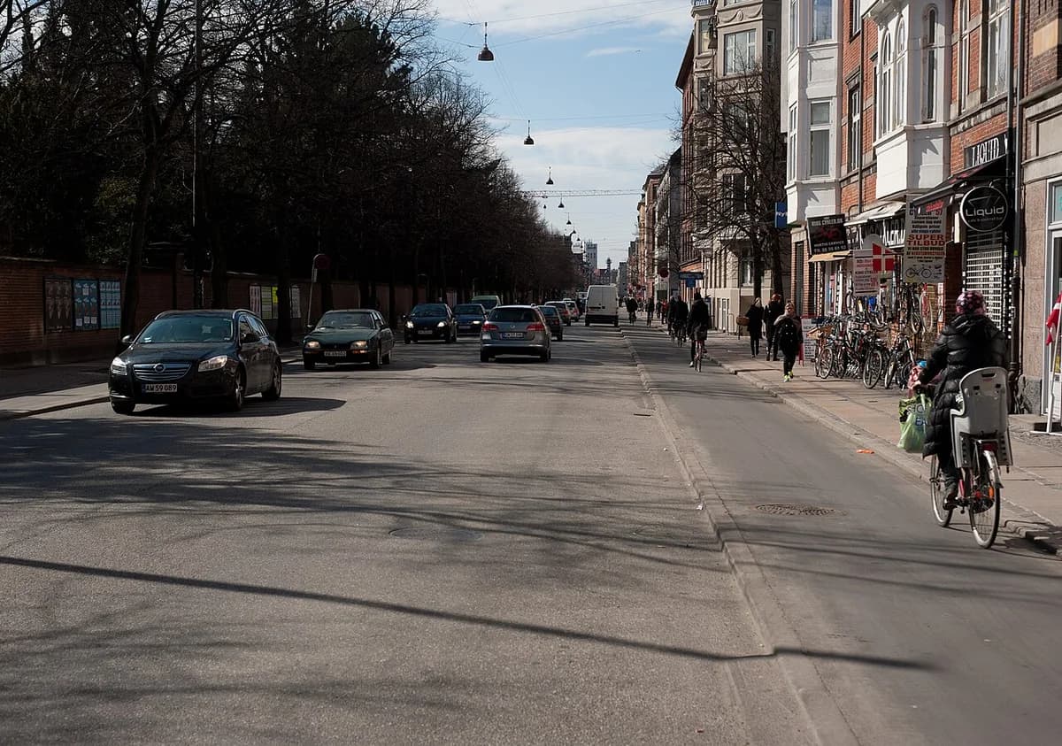A busy Copenhagen street with cars, bicycles, and pedestrians.