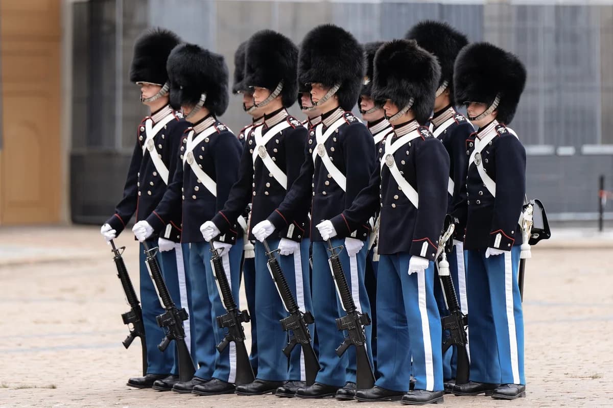 Royal Guards in blue uniforms and bearskin hats standing in formation at Amalienborg Palace
